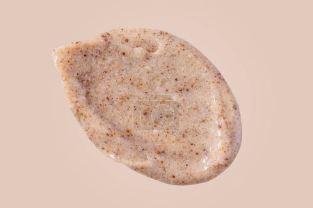 Téléchargez les photos : Scrub smear swatch isolated on beige background. Peeling cream smudge with exfoliating particles. Cosmetic skincare product with abrasive particle sample, gentle nude scrub texture isolate. - en image libre de droit