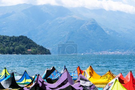 Foto de Kite surf tabla y cometas contra el lago y las montañas, kitesurf en el lago Como, Alpes, Italia. Concepto de deporte de viaje activo - Imagen libre de derechos