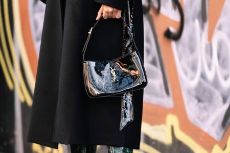 Foto de Milán, Italia - 13 de enero de 2023: la mujer lleva un bolso de cuero negro barnizado Yves Saint Laurent, detalles de estilo urbano - Imagen libre de derechos