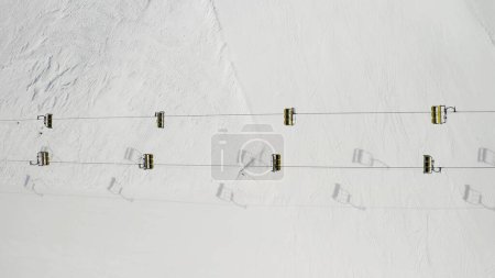 Photo for Aerial view of Livigno ski resort in Lombardy, Italy. Chairlifts, ski lifts, gondola cabin lifts are moving. View from above, top view. - Royalty Free Image