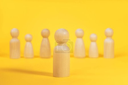 Téléchargez les photos : Concept de leader ou patron en équipe. Les gens en bois sur fond jaune. - en image libre de droit