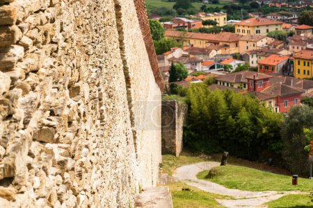 Cityscape of medieval Italian town Pietrasanta, old wall on the hill, roofs of houses, top view, Italy