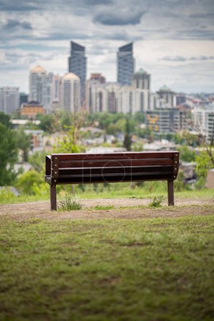 Eine Parkbank mit Blick auf die Skyline der Innenstadt von Calgary und beliebte Wahrzeichen in Alberta Kanada.