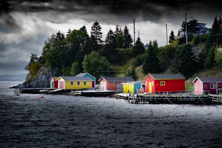 Photo for Boat sheds during a stormy day painted in different colours along the East coast of Canada in Dildo Newfoundland. - Royalty Free Image
