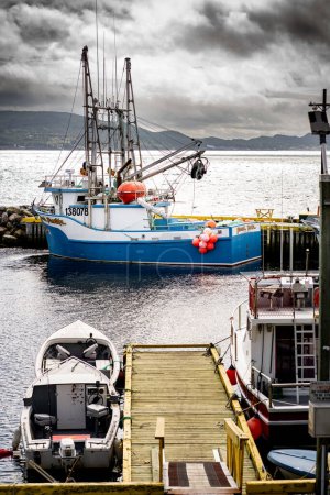 Foto de Dildo Newfoundland Canada, September 26 2022: Harbour view of a small tourist destination with a fishing trawler at the end of a dock on the East Coast. - Imagen libre de derechos