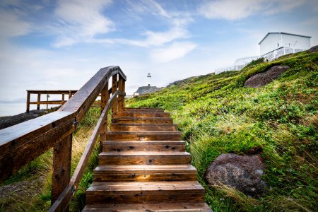 Téléchargez les photos : Escalier en bois avec rampe menant à un haut phare blanc et des bâtiments historiques surplombant l'océan Atlantique au cap Spear Terre-Neuve Canada. - en image libre de droit