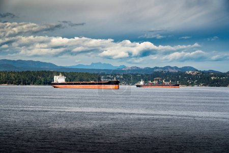Foto de Cargueros vacíos y buques portacontenedores anclados frente a la costa de la isla de Vancouver esperando ser cargados durante la huelga de trabajadores portuarios de BC en Nanaimo BC - Imagen libre de derechos