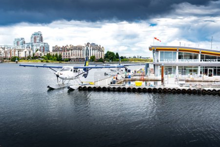 Photo for Victoria British Columbia Canada, July 12 2023: Harbour Air Seaplane docked at the Victoria Harbour air terminal overlooking distant apartment buildings. - Royalty Free Image