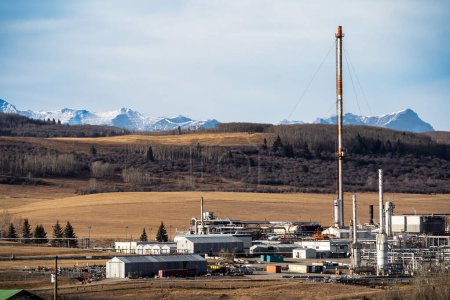 Téléchargez les photos : Rocky View County Alberta Canada, 22 novembre 2023 : Vue du paysage de l'usine à gaz Cochrane surplombant les champs de prairies avec les Rocheuses canadiennes à l'arrière-plan. - en image libre de droit