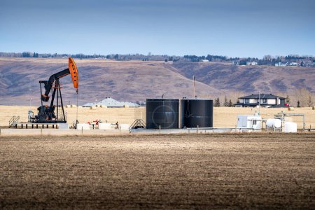 Foto de Pump jack trabaja en una propiedad rural para la industria del petróleo y el gas en Springbank Rocky View County Alberta Canada. - Imagen libre de derechos