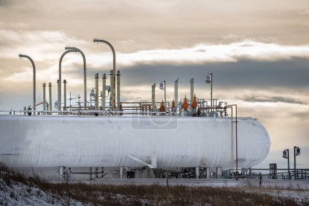 Téléchargez les photos : Cochrane Alberta Canada, 06 février 2024 : Grands réservoirs dans une usine de gaz industriel sous un ciel nuageux en soirée - en image libre de droit