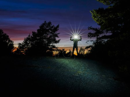 Téléchargez les photos : Chemin avec phare debout dans la forêt au coucher du soleil - en image libre de droit