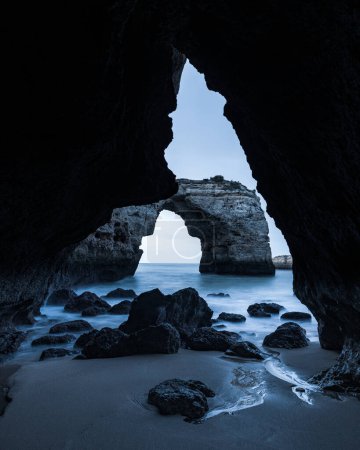 Rocas que yacen en la playa en la cueva costera, Algarve