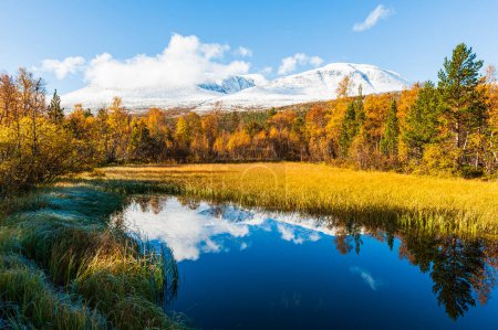 Photo for Autumn colors besides small lake in front of snow covered mountains - Royalty Free Image