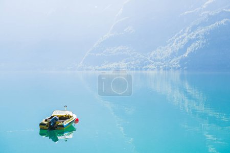 Photo for A peaceful motor boat moored in a tranquil Norwegian fjord, surrounded by majestic mountains and the calming sea - an idyllic display of beauty in nature. - Royalty Free Image