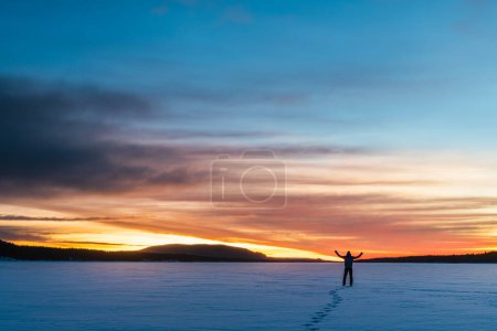 Foto de Hombre de pie en el lago congelado al amanecer - Imagen libre de derechos