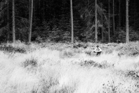 Photo for Boy biking on forest trail in black and white. - Royalty Free Image