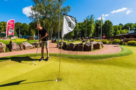 Téléchargez les photos : GOTHENBURG, SUÈDE - 1er AOÛT 2017 : Jeune garçon jouant au golf miniature - en image libre de droit