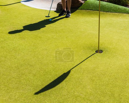 Téléchargez les photos : Jouer au golf miniature une journée ensoleillée - en image libre de droit