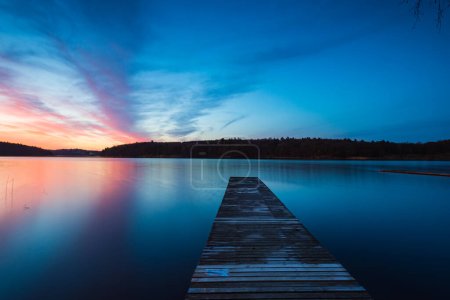 Wooden jetty at lake during sunrise