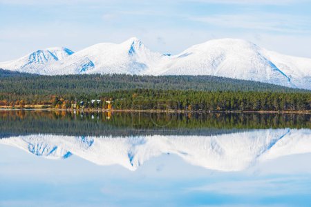 Foto de Montaña nevada y un bosque verde reflejado en un lago tranquilo - Imagen libre de derechos