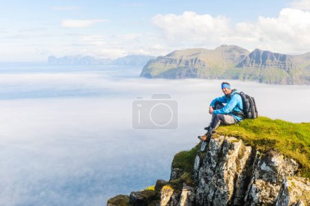 Téléchargez les photos : Randonneur assis avec vue. Mykines, Îles Féroé - en image libre de droit