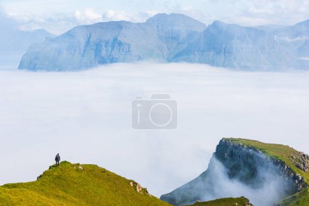 Photo for Hiking high above clouds in dramatic mountain scenery. Faroe Islands - Royalty Free Image
