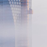An unfinished skyscraper in Gothenburg, Sweden is reflected off the foggy sky amidst a backdrop of billowing clouds and engineering work-in-progress.