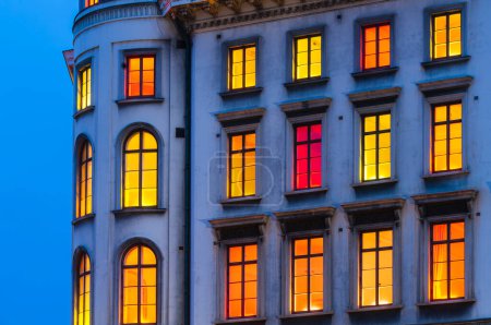 Photo for Colorful illuminated windows on building at dusk - Royalty Free Image