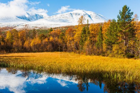 Photo for Autumn colors besides small lake in front of snow covered mountains - Royalty Free Image