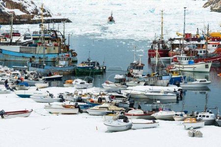 Foto de ILLULISSAT, GRANDA - 28 DE ABRIL DE 2014: Barcos pesqueros amarrados en un puerto nevado - Imagen libre de derechos