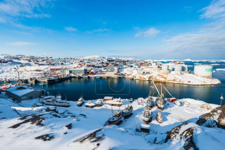 Photo for ILLULISSAT, GREENLAND - APRIL 28, 2014: Fishing boats moored in a snowy harbour - Royalty Free Image