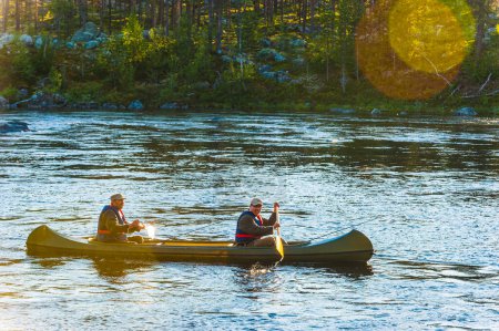 Photo for Two men paddling a canoe on river - Royalty Free Image