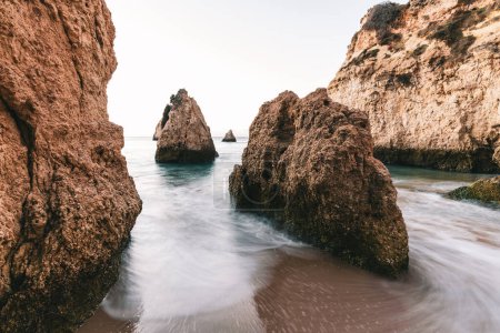 Téléchargez les photos : Formations rocheuses rugueuses sur une plage de sable fin, Alvor, Algarve, Portugal, Europe - en image libre de droit
