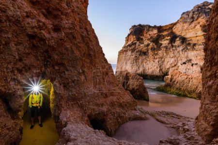 Foto de Hombre de pie junto al acantilado con faro iluminado, Alvor, Algarve, Portugal, Europa - Imagen libre de derechos