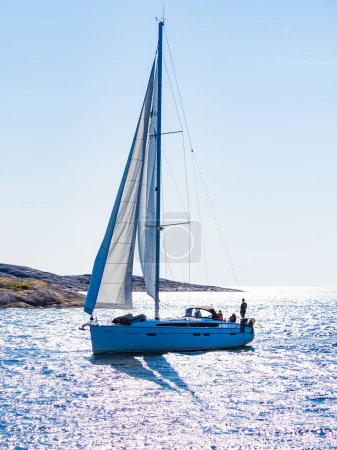 Téléchargez les photos : Voilier sur des eaux bleues claires avec un ciel ensoleillé. - en image libre de droit