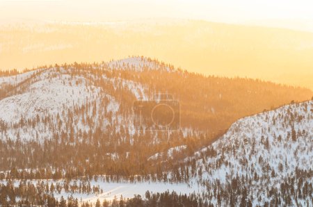 Téléchargez les photos : Paysage hivernal tranquille en Norvège : arbres enneigés, montagnes et coucher de soleil serein. - en image libre de droit