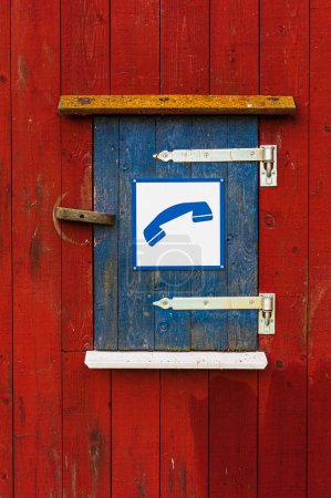 Photo for Wooden cabinet with red and blue doors and phone symbol sign. - Royalty Free Image