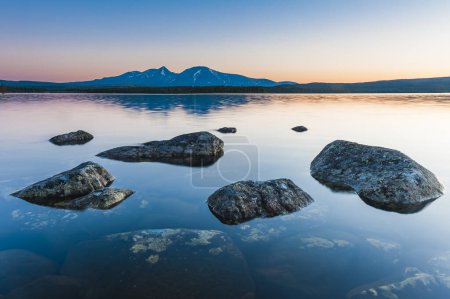 Photo for A serene landscape with mountains, a lake, and calming colors. - Royalty Free Image