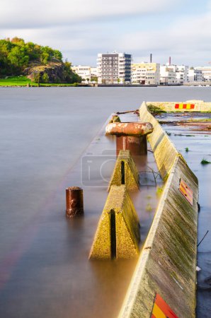 Téléchargez les photos : Jetée de béton faisant saillie dans une rivière - en image libre de droit