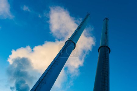 Téléchargez les photos : Fumée et cheminées contre le ciel bleu - en image libre de droit