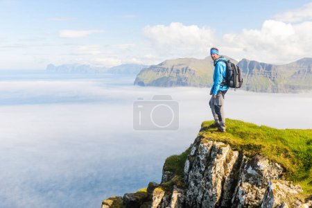 Téléchargez les photos : Randonneur debout sur une falaise, Mykines, Îles Féroé - en image libre de droit