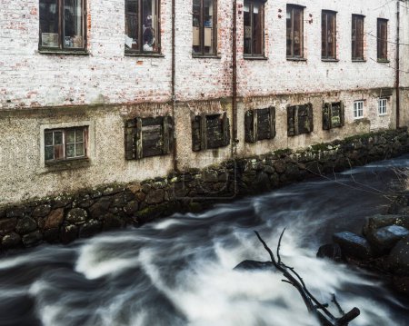 Foto de Edificio histórico de ladrillo por el flujo de agua en Mlndal, Suecia - Imagen libre de derechos