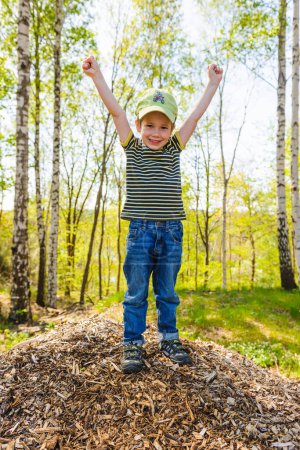 Foto de Niño feliz de pie frente al bosque de primavera - Imagen libre de derechos