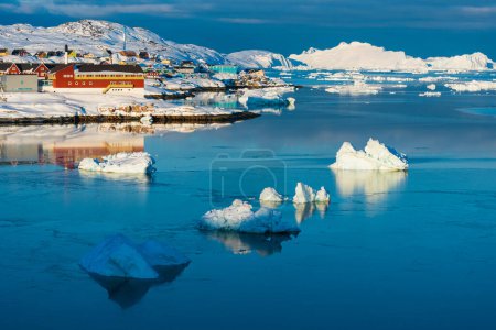 Téléchargez les photos : Icebergs devant les bâtiments du village Ilulissat, Groenland - en image libre de droit