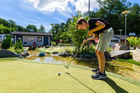 Téléchargez les photos : GOTHENBURG, SUÈDE - 1er AOÛT 2017 : un garçon joue au mini-golf par beau temps - en image libre de droit