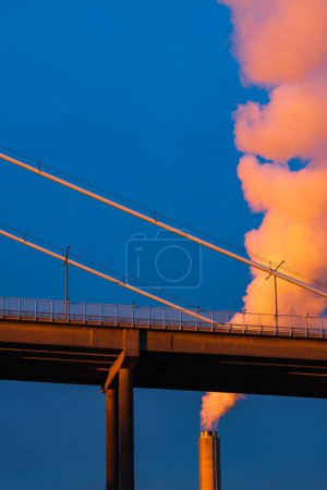 Photo for Industrial chimney billowing smoke into blue sky, low angle view, vertical image, space for copy, Gothenburg, Sweden, Europe - Royalty Free Image