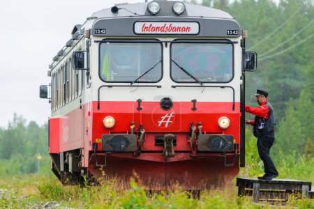 Téléchargez les photos : JOKKMOKK, SUÈDE - 7 AOÛT 2015 : Un conducteur de train entre dans une locomotive - en image libre de droit