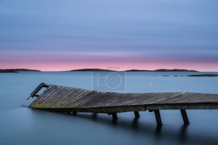 Photo for Broken pier on calm lake with dramatic sky - Royalty Free Image