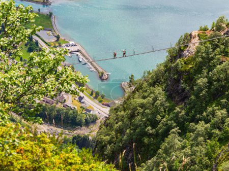 Téléchargez les photos : Aventure norvégienne : Deux personnes traversent un pont, entourées par la beauté de la nature. - en image libre de droit